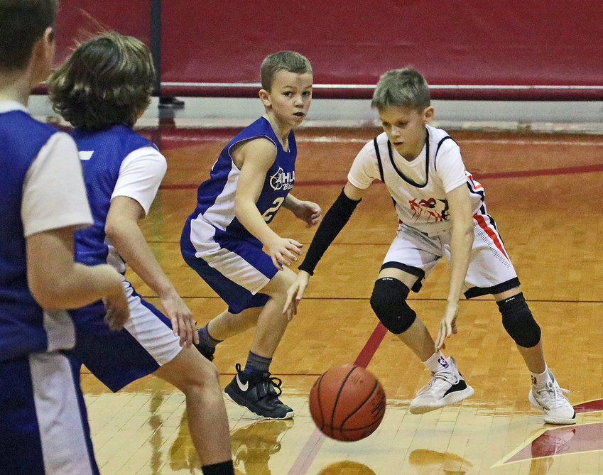 Fort Calhoun fourth-grader Blake Feinhold, right, dribbles Saturday at Gardner-Hawks Center.