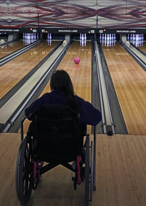 April Ward watches her bowling ball approach a spare Saturday at Maplewood Lanes.