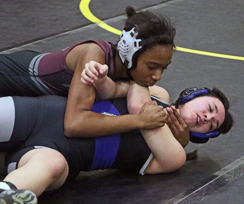Arlington 125-pounder Kelise Krivohlavek, top, works to pin Millard North's Ryleigh Eckles on Friday during the District 1 Tournament at Fremont High School.