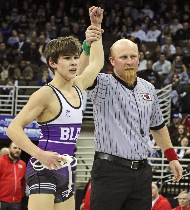 Blair state champion Hudson Loges has his hand raised Saturday at the CHI Health Center in Omaha.