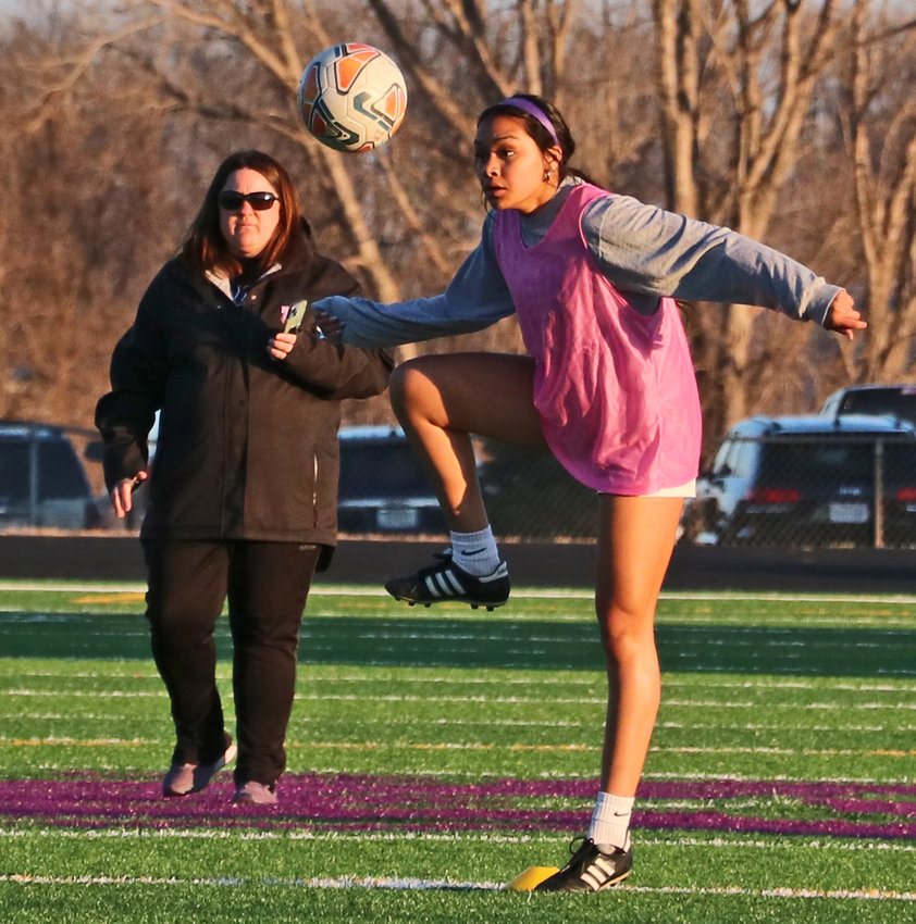 Senior Allison Hernandez, right, knocks down the ball for possession in front of coach Ashley Brown on Thursday during BHS soccer practice at Krantz Field.