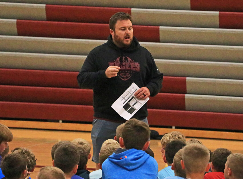 Arlington High School football coach Colter Mattson talks to campers in the huddle Monday at AHS.