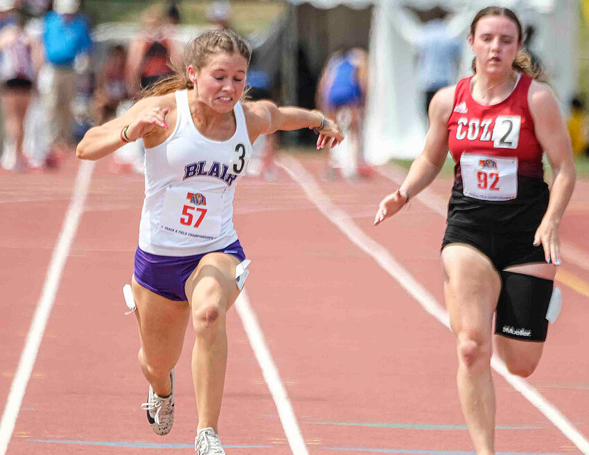 Blair junior Reese Beemer, left, races to the finish line Wednesday at Omaha Burke Stadium.