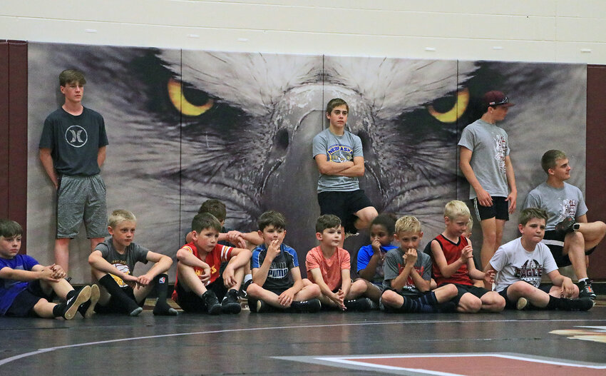 Camper and high school wrestlers listen to instructions Tuesday at Arlington High School.