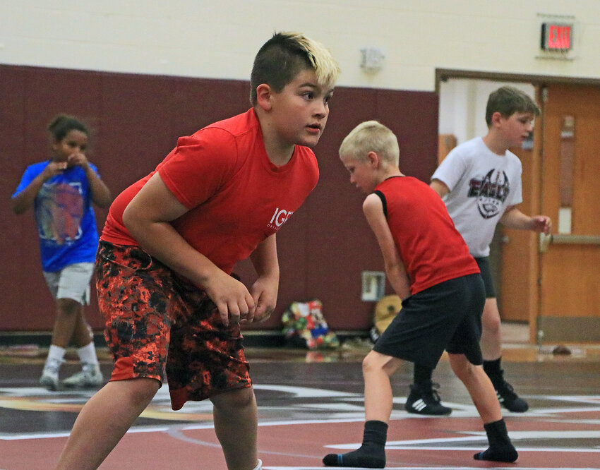 EJ Lozo, 9, works on his wrestling stance Tuesday at Arlington High School.