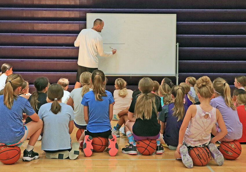 Hoopers in grades 2-5 sit and watch Bears coach Matt Aschoff work at the white board Tuesday during the Blair High School girls basketball camp. Each of the four-day camp days opened with a high school session before two more camps with grades 6-8 and 2-5. More than 30 kids took part in the middle school session before nearly 50 participated in the elementary camp.