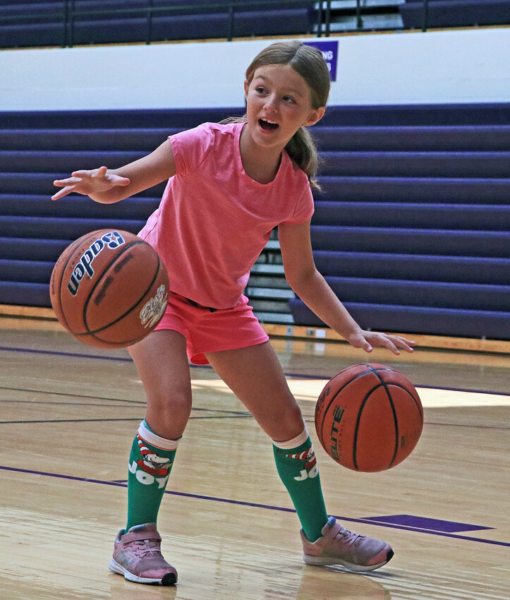 Mackenzie Moeller, 7, dribbles two basketballs Tuesday during the Blair High School girls basketball camp.