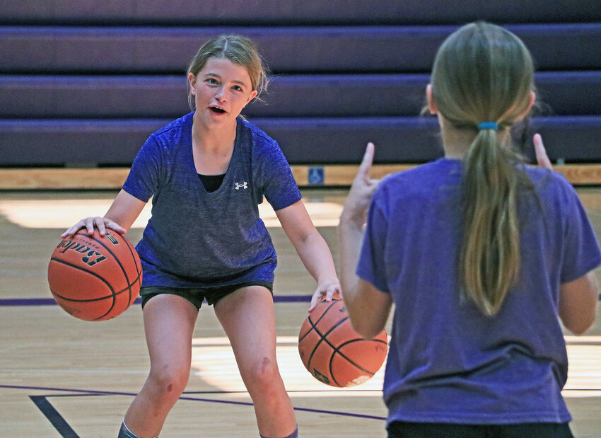 Adley Tessendorf, 10, left, works on her dribbling with a teammate Tuesday at Blair High School.