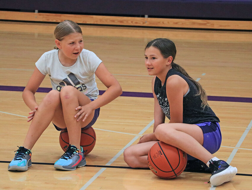 Jenica Henton, 10, left, and Bree Archer, 10, hang out before the start of basketball camp Tuesday at Blair High School.
