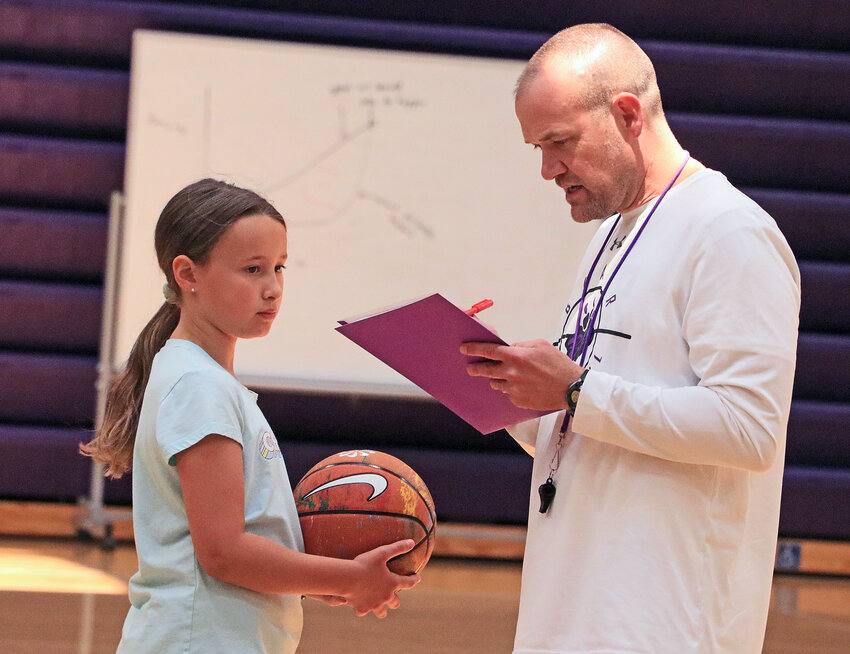 Madilyn Carnley, 9, left, checks into camp with Bears coach Matt Aschoff on Tuesday at Blair High School.