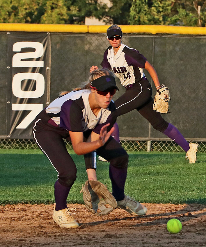 Blair shortstop Nessa McMillen, left, fields a ground ball as Sophia Wrich backs her up in the outfield Monday at Omaha Skutt.