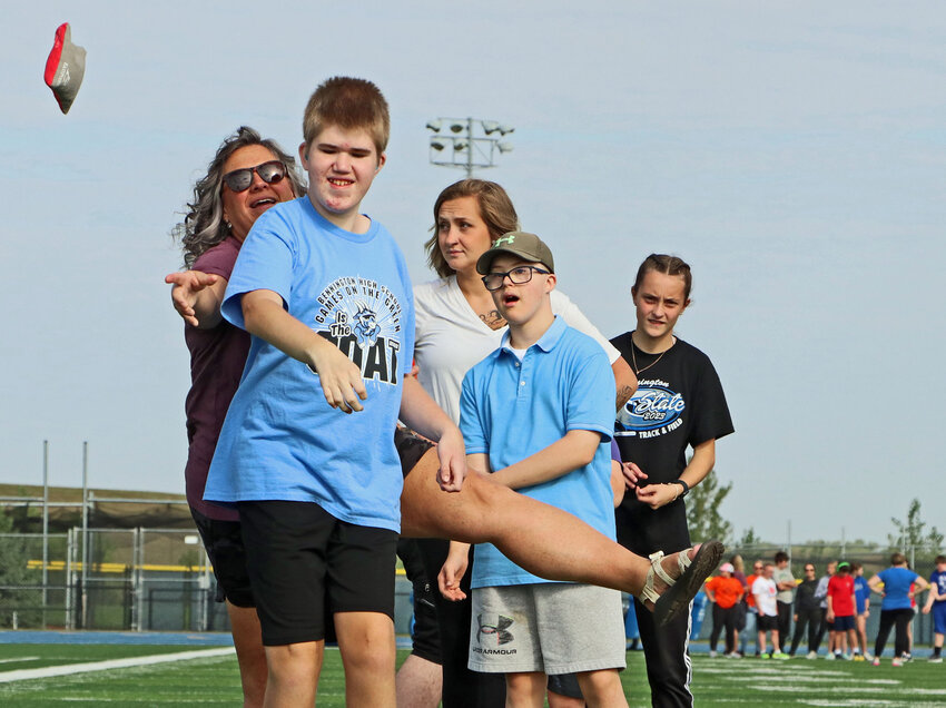 Nick Eddie of Arlington throws a bean bag with some help from paraeducator Cher Krause, left, on Thursday during the second annual Games on the Green at Bennington High School. Students and special education teachers from Arlington, Blair and Fort Calhoun all took part.