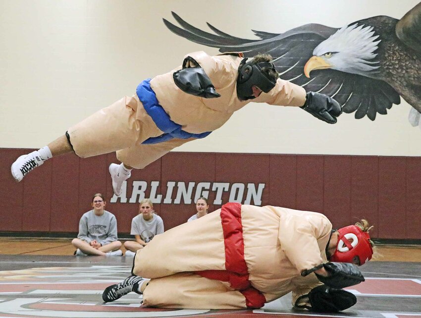 Eagles wrestler Stokely Lewis, bottom, rolls out of the way of a soaring Kolton Gilmore on Nov. 21 during the sumo portion of Arlington High School's intrasquad scrimmage.