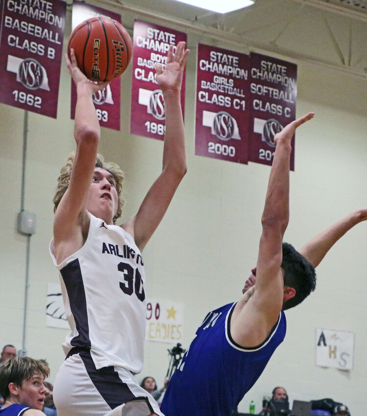 The Eagles' Trent Koger puts up a shot in the lane Saturday at Arlington High School.