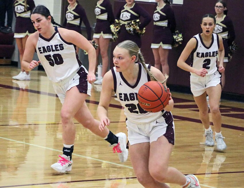The Eagles' Austyn Flesner, middle, dribbles up the floor as Taylor Arp, left, and Emme Timm trail the play Monday at Arlington High School.