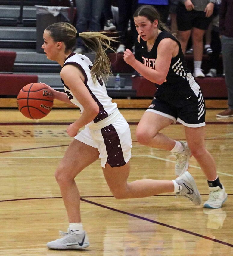 Eagles point guard Emme Timm, left, dribbles down the floor as North Bend Central's Reese Petersen gives chase Monday at Arlington High School.