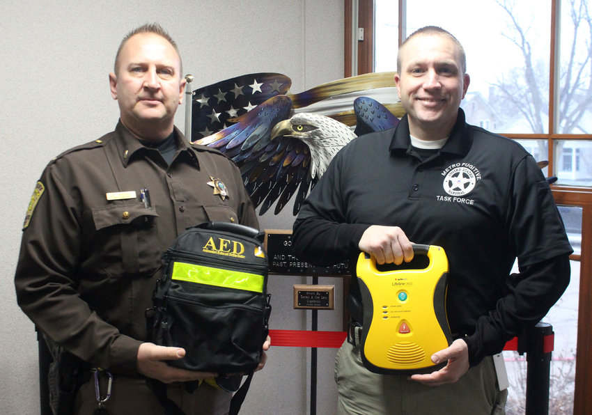 Lt. Butch Groves, left, and Capt. Aaron Brensel hold one of the 16 new automated external defibrillators that will be placed into patrol vehicles. The Washington County Sheriff's Office purchased the devices through donations.