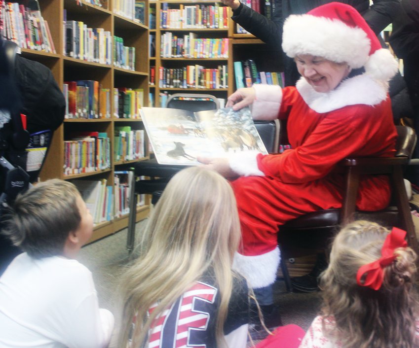 Kids sit and listen to stories told by Mrs. Claus at the Fort Calhoun Library during the eighth annual Christmas in Calhoun events held on Dec. 14 last year.