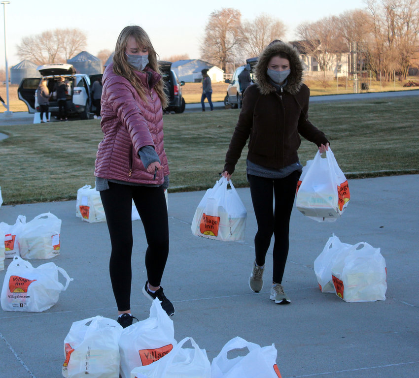 Alayna Prunty, left, and Angel Nelson walk pies to the front of Fort Calhoun Jr/Sr High School Thursday. The girls are part of the Fort Calhoun cheer team, and raised $600 in funds for the pies.