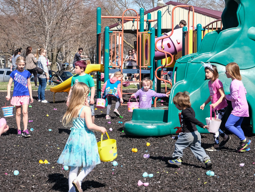 Kids search high and low for plastic easter eggs during the Arlington Egg Adventure.