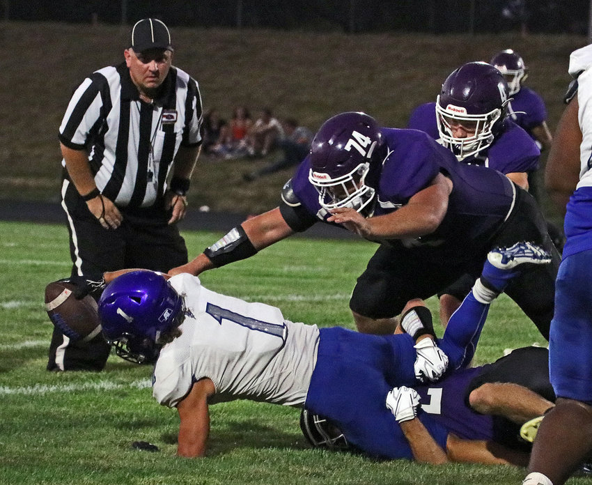 Plattsmouth running back Christian Meneses stretches for extra yards as he's pulled down by Conner O'Neil, bottom, and Wyatt Ogle (74) on Friday at Krantz Field.