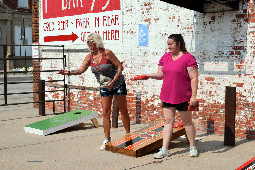 Loretta Musgrave, left, and Terri Musgrave try their hand at the corn hole tournament at Petersen&rsquo;s Bar 75 for Herman Days on Saturday. .