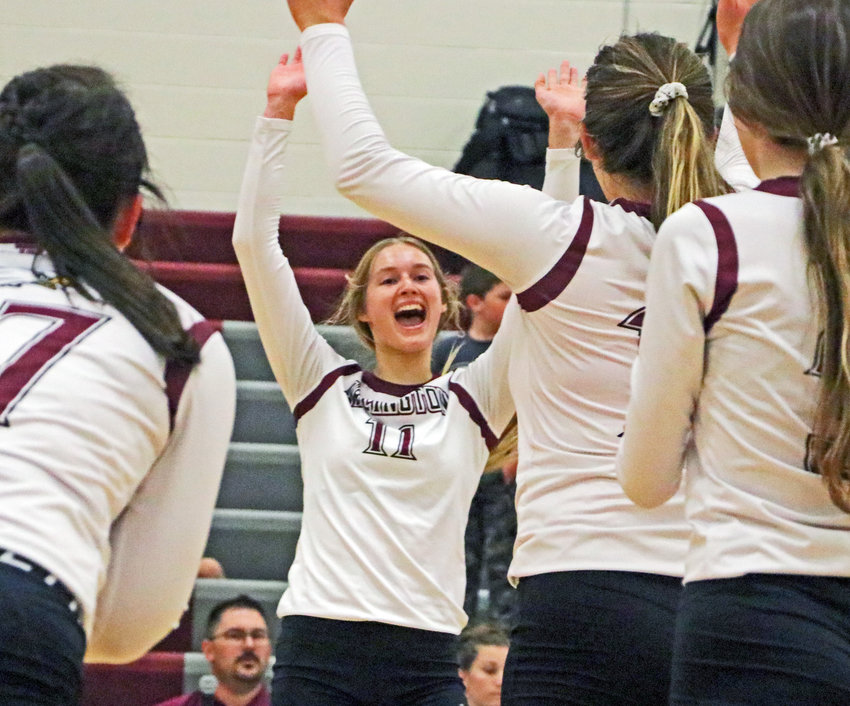 Eagles senior Chase Andersen, middle, celebrates a point with her teammates Tuesday at Arlington High School.