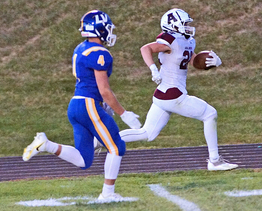 Arlington Eagle Nick Smith races down the sideline for a second quarter touchdown as the Raiders' Alex Foust gives chase Friday at Logan View High School.