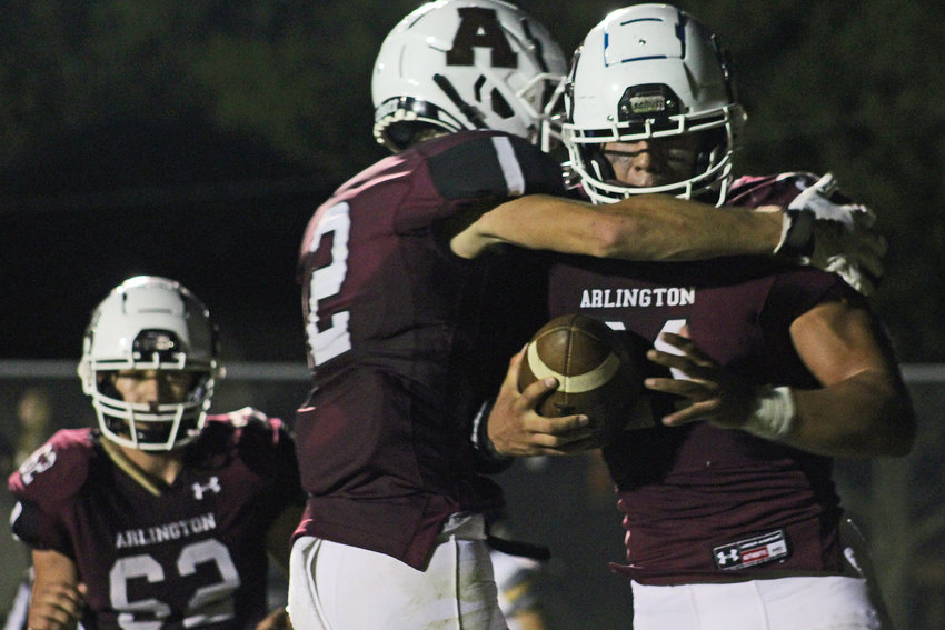 Eagles senior Collin Burdess, right, celebrates a touchdown with Dustin Kirk, middle, and Weston Wollberg on Friday at Arlington High School.