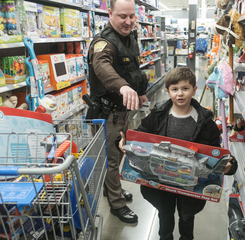 Lyric Greene shops with deputy Jack Dein during the annual Shop with a Deputy at Walmart Wednesday evening.