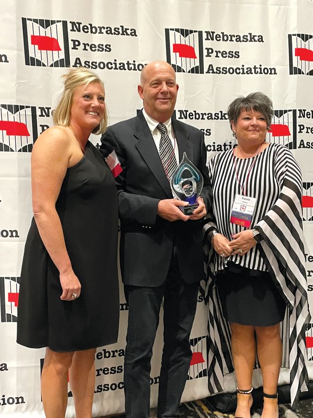 Enterprise Media Group publisher Mark Rhoades, center, accepts the Omaha World-Herald's award for Dedication to Service from Amy Johnson, outgoing Nebraska Press Association President, left, and Terrie Baker, incoming NPA president.