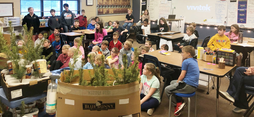 Oakland-Craig third and fourth grade students listen to a presentation on the importance of planting trees.