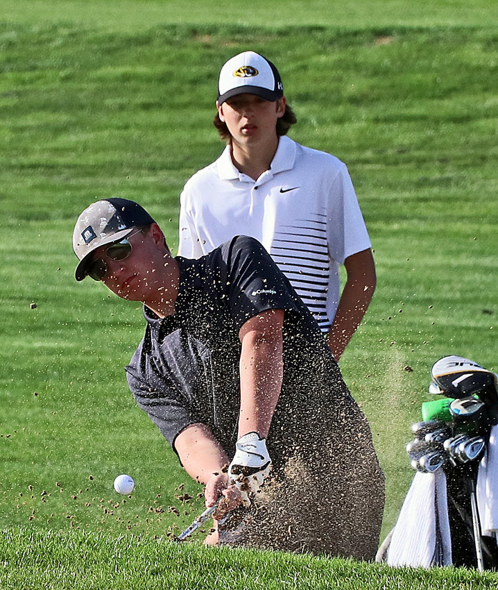 Blair Bear Landen Oppliger chips out of the bunker on hole No. 9 Monday at River Wilds Golf Club.