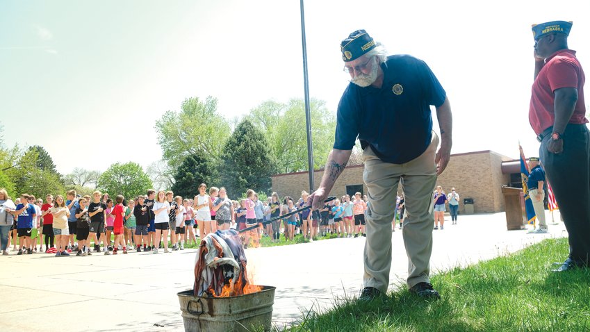Arbor Park students stand with hands over their hearts as Legion members incinerate a retired flag during a flag education class at Arbor Park May 11.