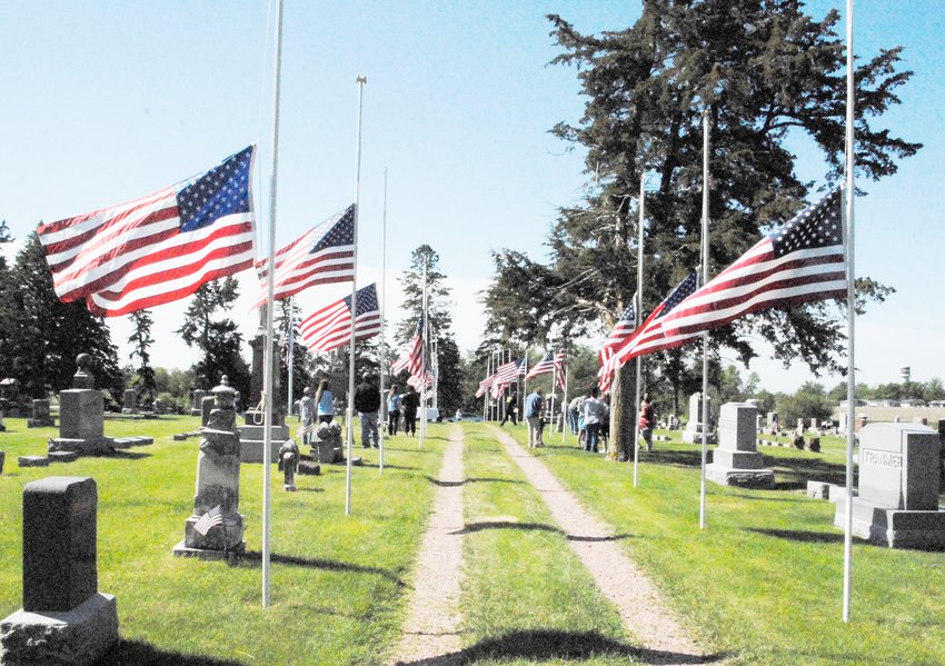 A person can feel the honor and solidarity with the flags flying half staffed along the avenue of flags in the Lyons Cemetery.