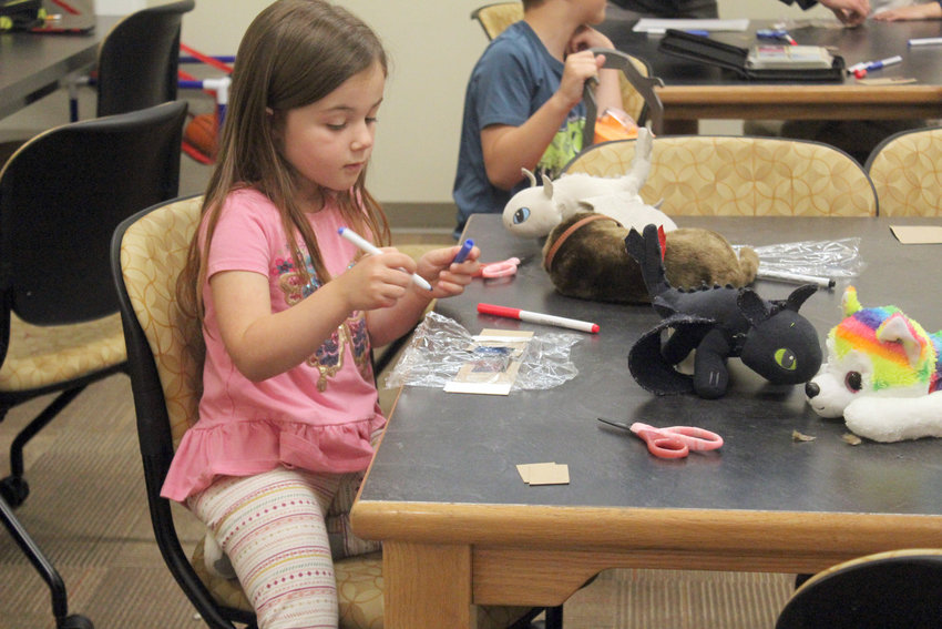 Taya Cuva, a kindergartner at Fort Calhoun Elementary, creates 3D glasses during the first week of the Pioneer Adventure Club summer program Wednesday. The program, which will commence through Aug. 5, will feature different activities for students to participate in, including science, technology, engineering and math.
