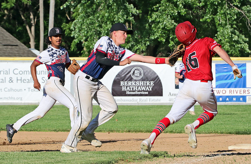 Blair Junior Legion first baseman Lucas Matejka, middle, tags an Elkhorn Training Camp Knight on Tuesday at Vets Field as Post 154's Lee Chavez-Lara, left, lends support.