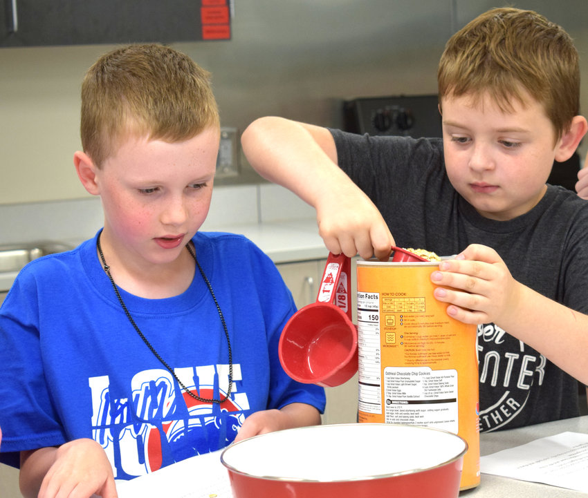 Haden Martens, left, and Nate VonSeggern prepare the oats for the tasty treat in their STEAM class.