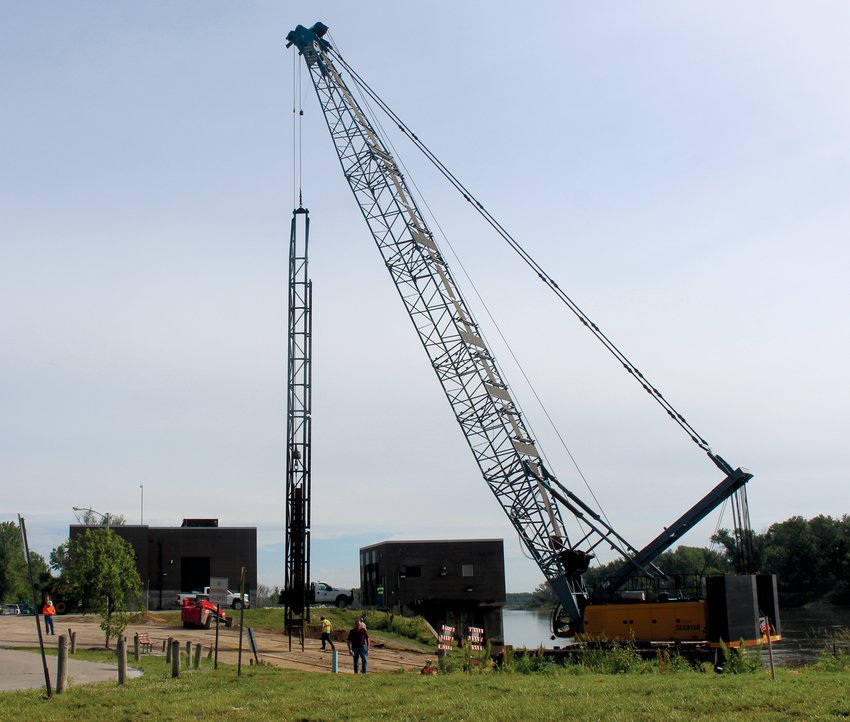 A large crane readies to place pilings for the new boat dock at Optimist Park.