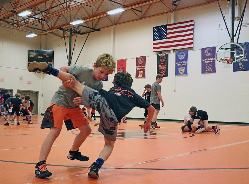 Paxton Mann, 8, left, takes down Laykyn Bernasek, 9, on Wednesday during the Pioneer Wrestling Club Camp at Fort Calhoun High School.