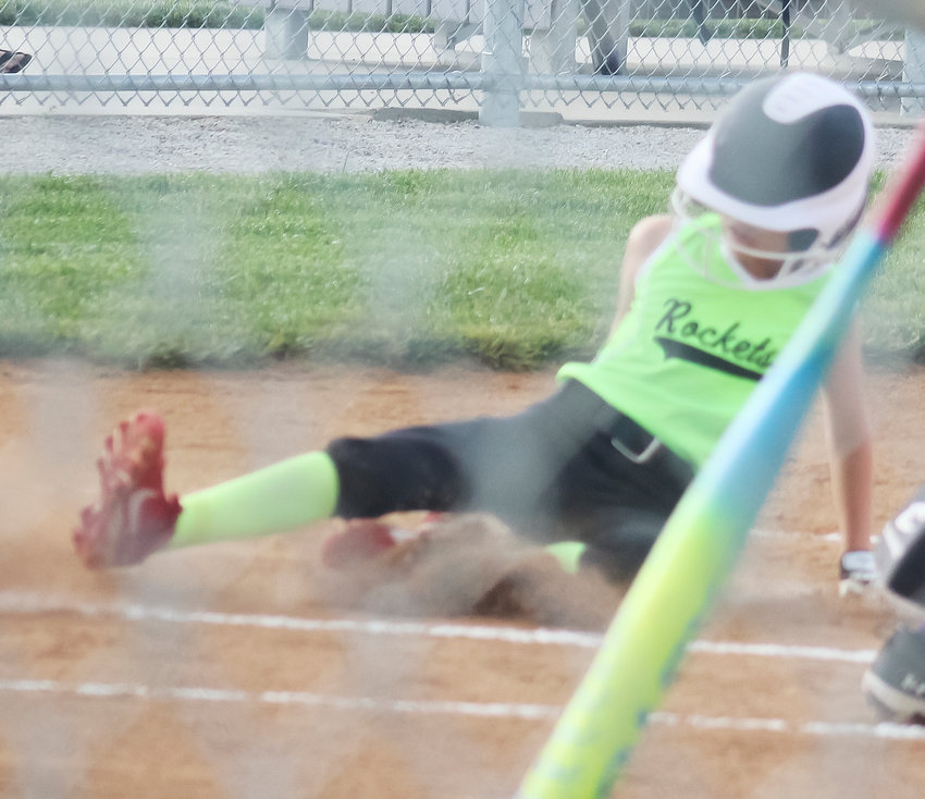 Sabrina Rost slides in at home plate for the Rockets first score in their game at District with Blair.