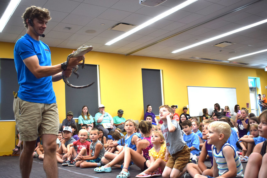 Will Abler of Real Reptiles shows off a small alligator to a group of kids at the Blair Public Library and Technology Center Tuesday.