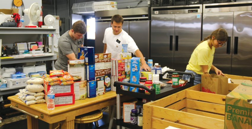 Volunteers organize some of the nearly one thousand pounds of food donated to the Washington County Food Pantry at Joseph's Coat on June 23 as part of its Pack the Pantry food drive.