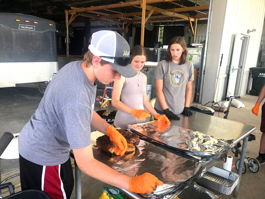 FFA members Aaron Fuchs, Kynlea Klevelan and Katie Moss help with food at a recent tractor pull.