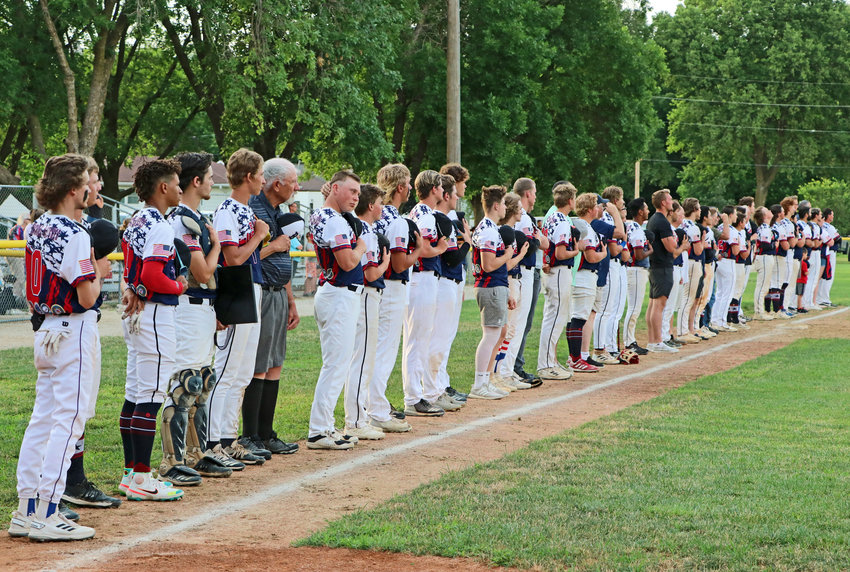 Blair American Legion baseball players stand with veterans Tuesday during a Millitary Appreciation ceremony at Vets Field.