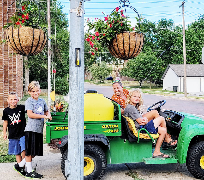 The Sperling Family, (from left) Tobias, Edmund, Ashley and Silas Sperling are among the volunteers ensuring the flower pots and baskets on Oakland Ave. continue to bloom.