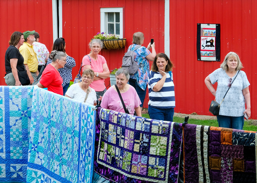 Visitor amble along fences and cattle panels displaying over 150 quilts off all shapes and sizes.