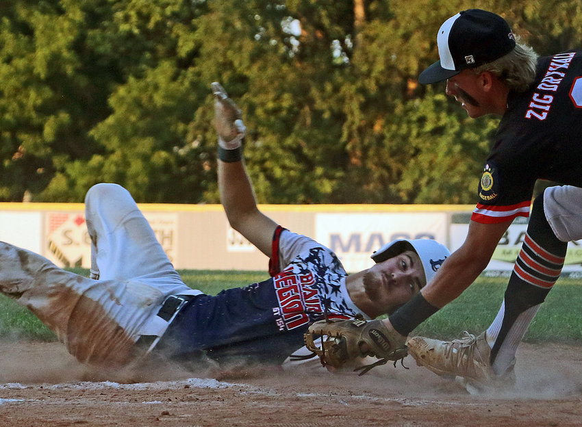 Blair Senior Legion base runner Conner O'Neil, left, slides in safe around the tag of Fort Calhoun's Ty Hallberg on Friday during the Class B Area 3 Tournament at Vets Field.