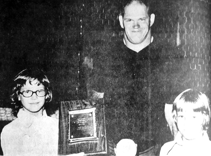 Kris McKay, left, and Kim McKay, right, stand with Chuck Bendorf in 1972, holding a plaque and softball commemorating the umpires more than 1,000 Blair games.