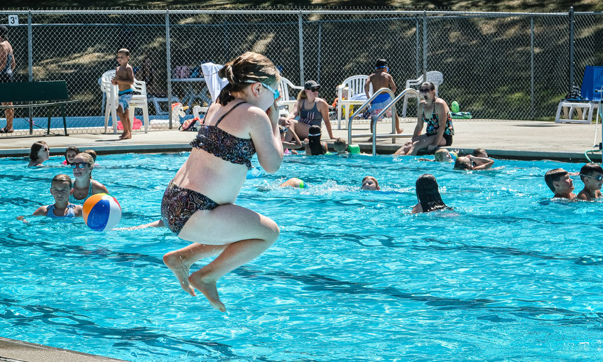 Emma Shamburg leaps into the swimming pool on Aug. 9. The pool closed for the season following the Doggie Splash on Saturday.